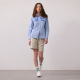 A woman modeling a blue Oxford shirt with blue swallows hand printed on the front, by fauna.ie