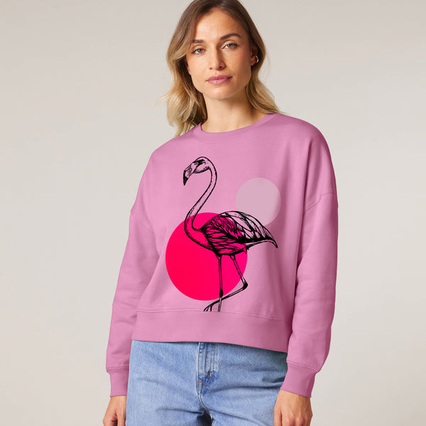 Person wearing a pink sweatshirt with a flamingo design by fauna.ie