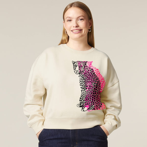 Woman wearing a cream sweatshirt with a colorful leopard print design by fauna.ie